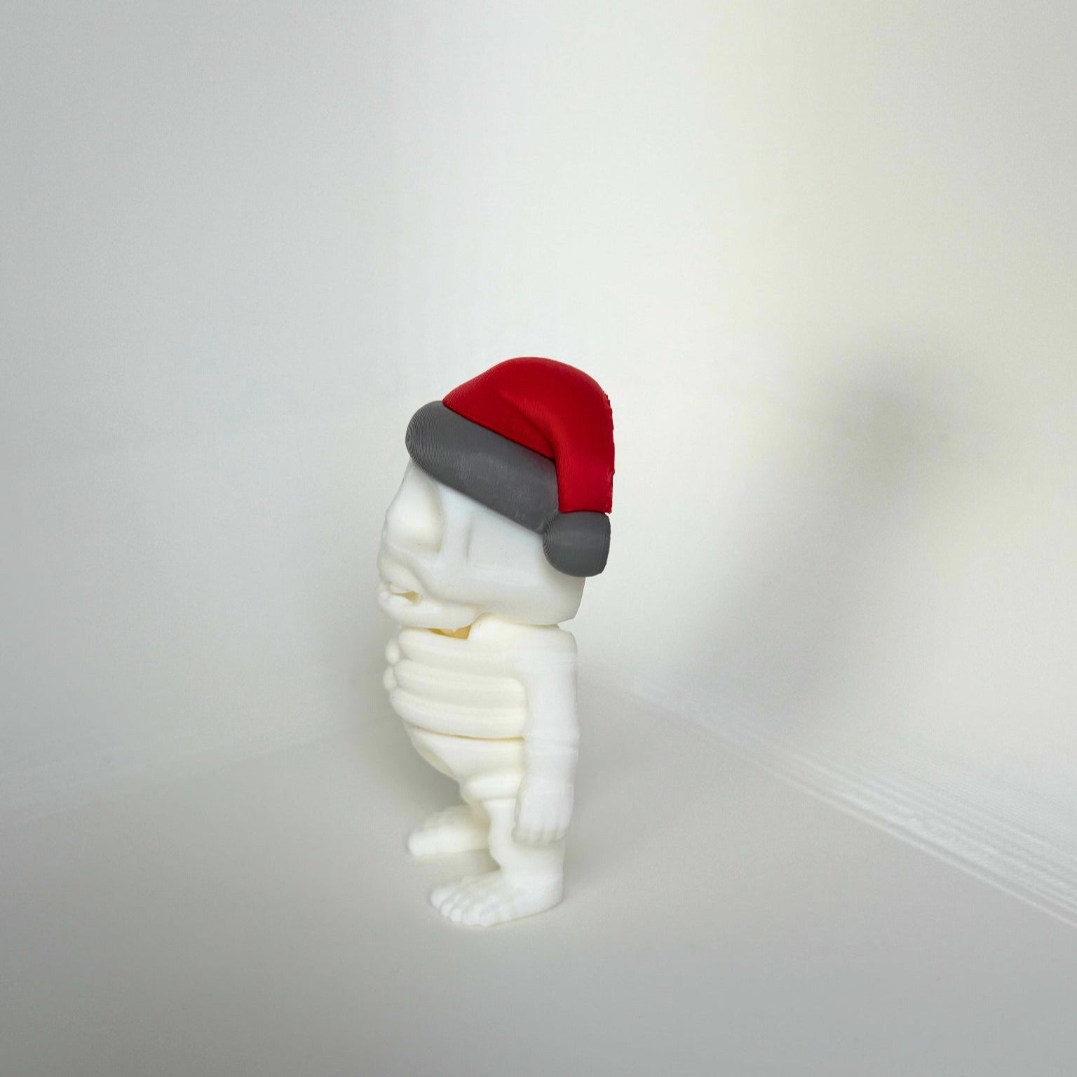 Zijaanzicht van een 3D-geprint skeletfiguur met kersthoed – kindvriendelijk en milieuvriendelijk