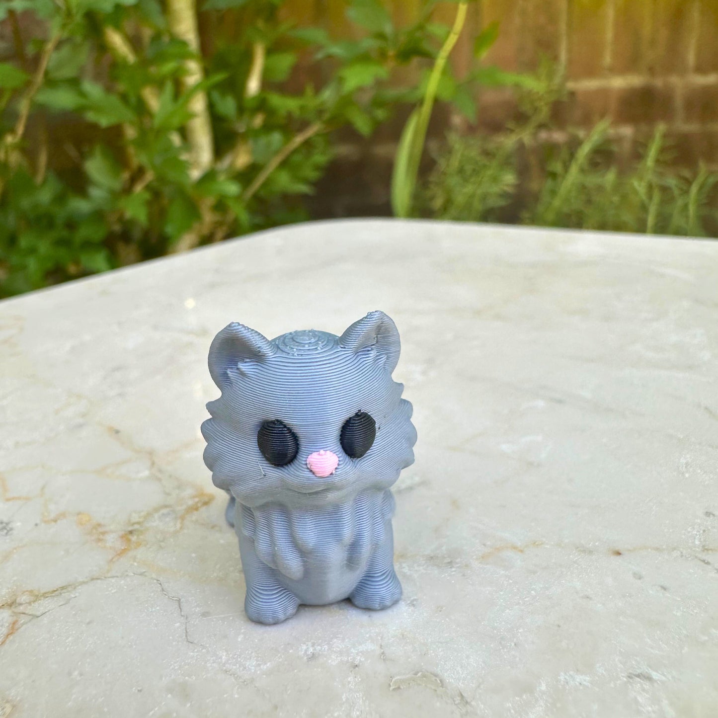 Vooraanzicht van grijs 3D geprint flexibel katje, duurzaam speelgoed van PLA voor kinderen.
