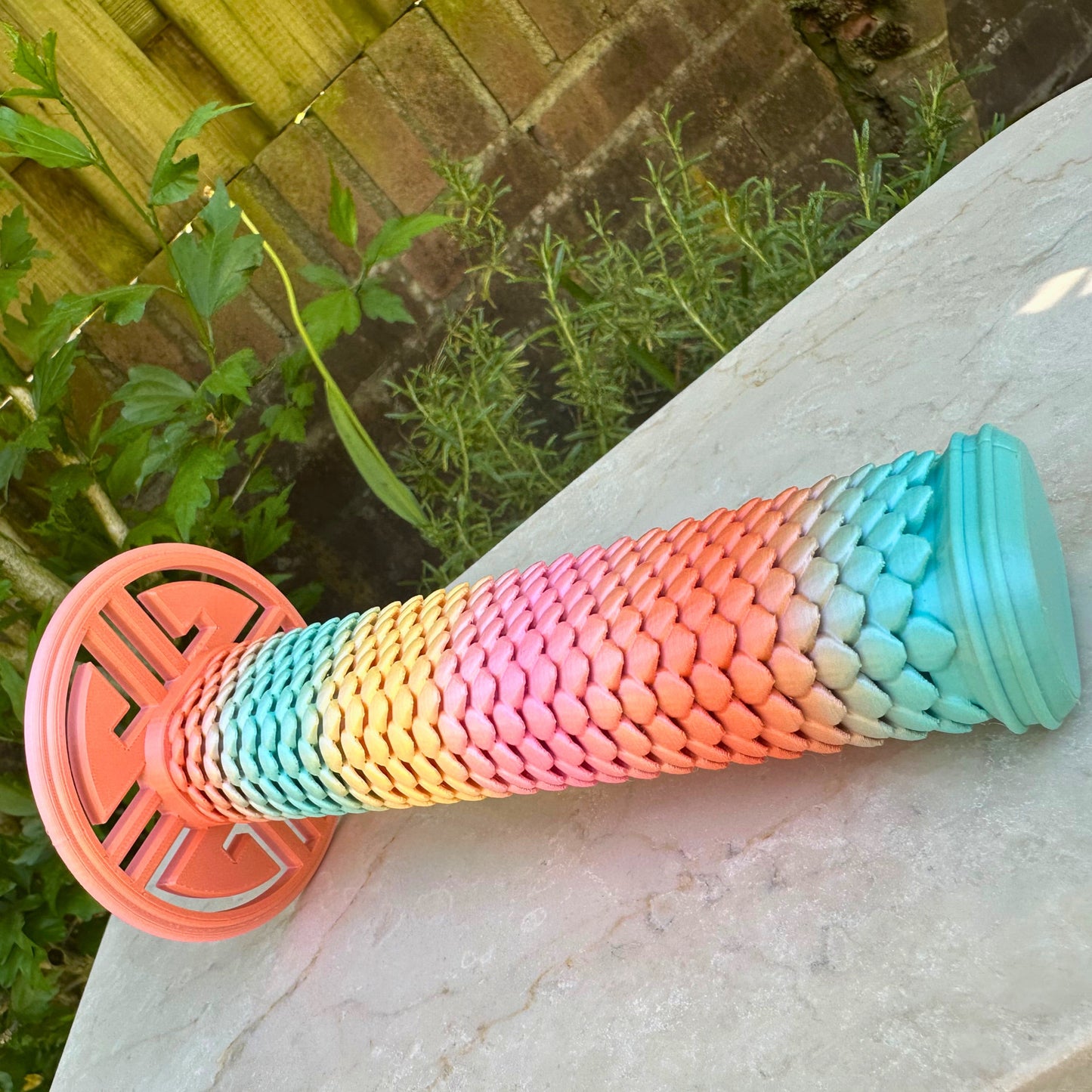 Close-up van het regenboogkleurige "drakenhuid" handvat van de uitschuifbare 3D geprinte speelgoed katana.