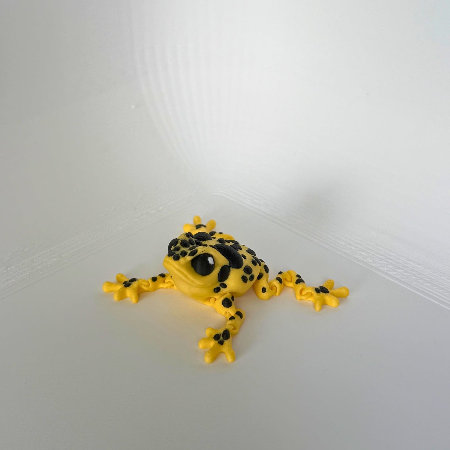 PLA speelfiguur van een amazone gifkikker – gele en zwarte 3D-geprinte articulerende kikker, zijaanzicht