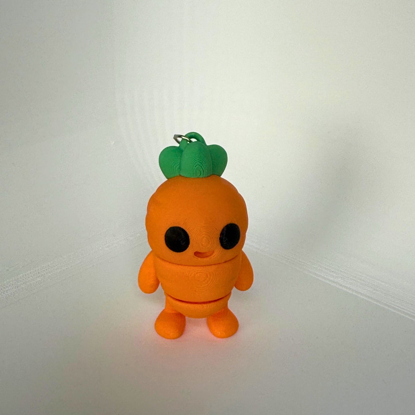 Articuleerbare wortel sleutelhanger – staand speelgoedfiguur van PLA met grote ogen en bladgroene top