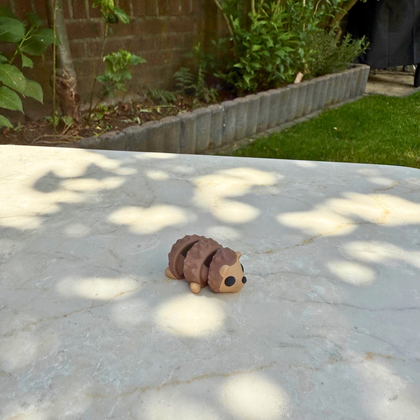 Vooraanzicht van een schattig 3D geprint baby flexi egeltje, duurzaam PLA speelgoed.