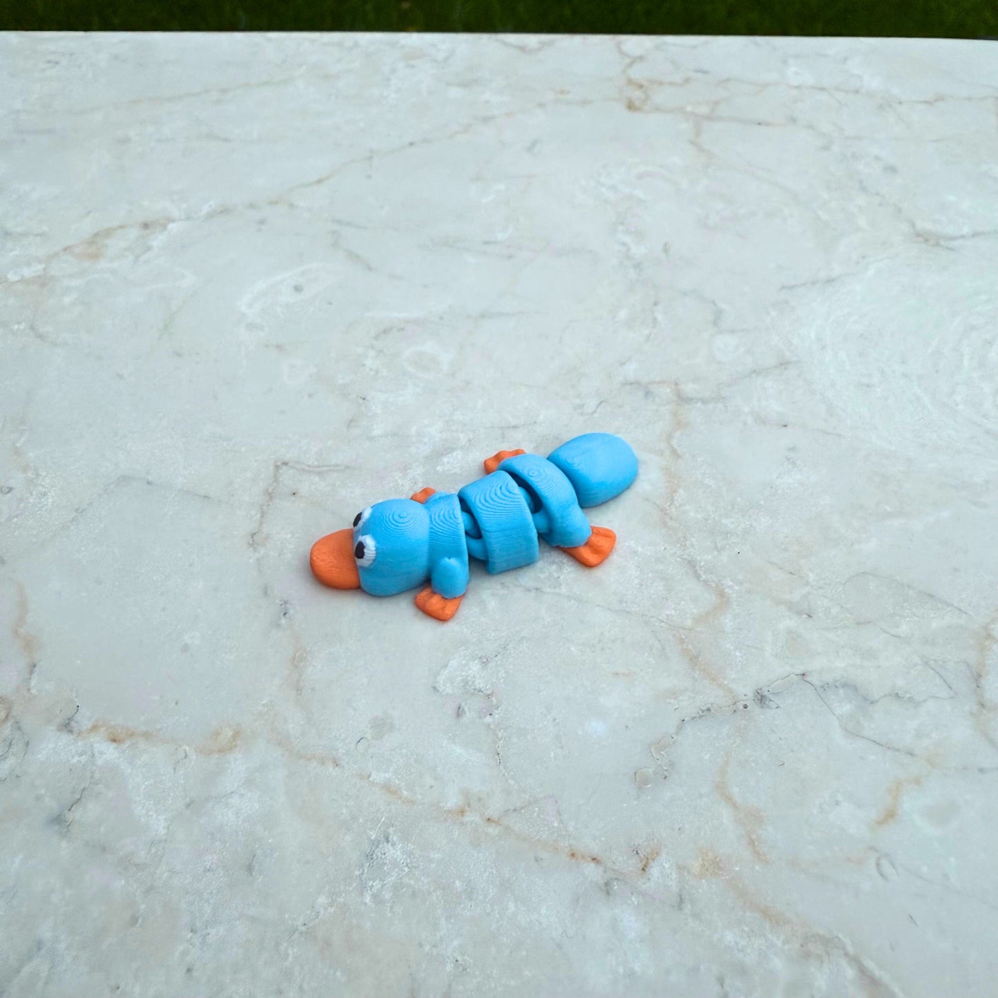 Detail van een 3D geprinte speelgoed vogelbekdier, toont de articulatie en unieke vorm.