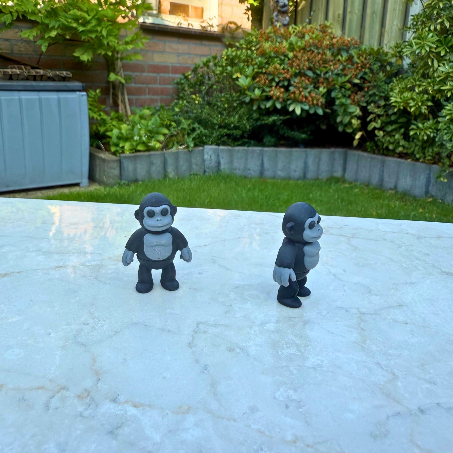 3D geprinte speelgoed gorilla's, een staand en een van opzij gezien, tonen de articulatie.