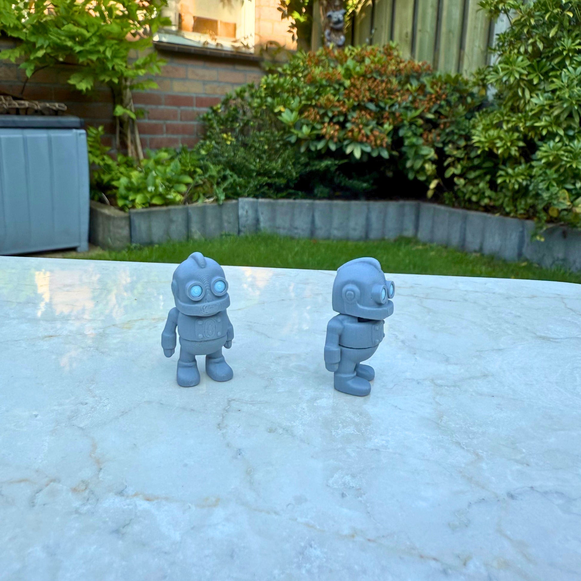 Flexibel 3D geprint speelgoed robot in een actiepose, toont de articulatie, eco-vriendelijk.