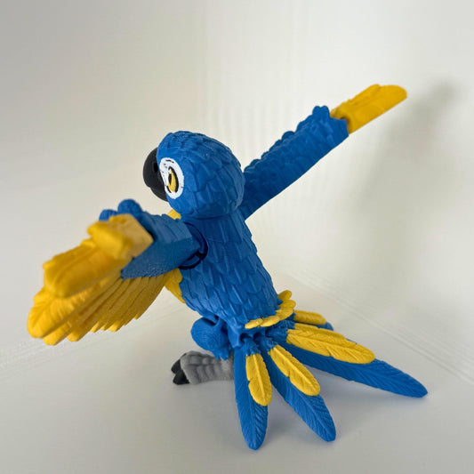 Zijkant van een kleurrijke blauwe papegaai met gele accenten, in een dynamische houding voor extra speelplezier.