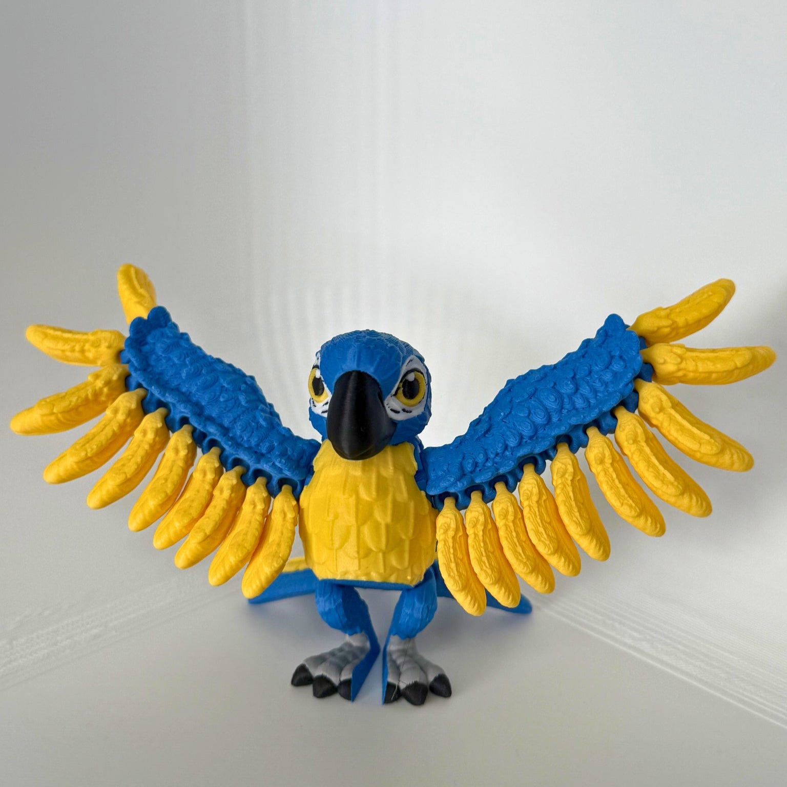 Speelse papegaai met uitgespreide blauwe en gele vleugels, perfect voor kindvriendelijk milieuvriendelijk speelgoed.