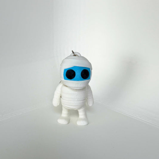 Duurzaam speelgoed: wit mummie sleutelhanger figuur met zwarte ogen en blauw gezicht, vooraanzicht