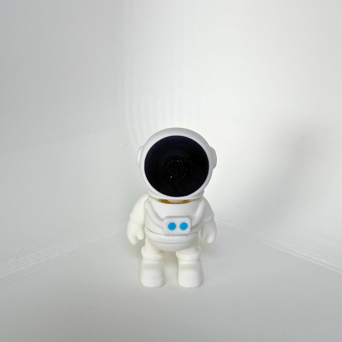 Duurzaam speelgoed: wit astronaut speelfiguur met zwarte helm en blauwe details, vooraanzicht