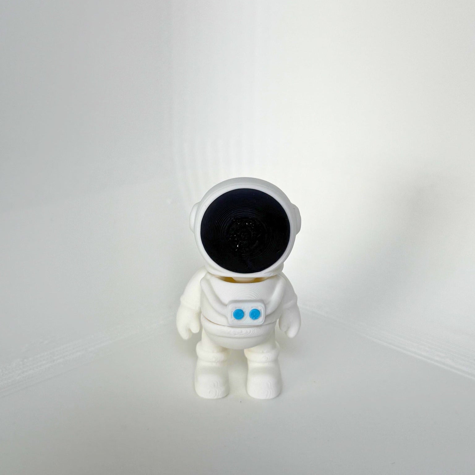 Duurzaam speelgoed: wit astronaut speelfiguur met zwarte helm en blauwe details, vooraanzicht
