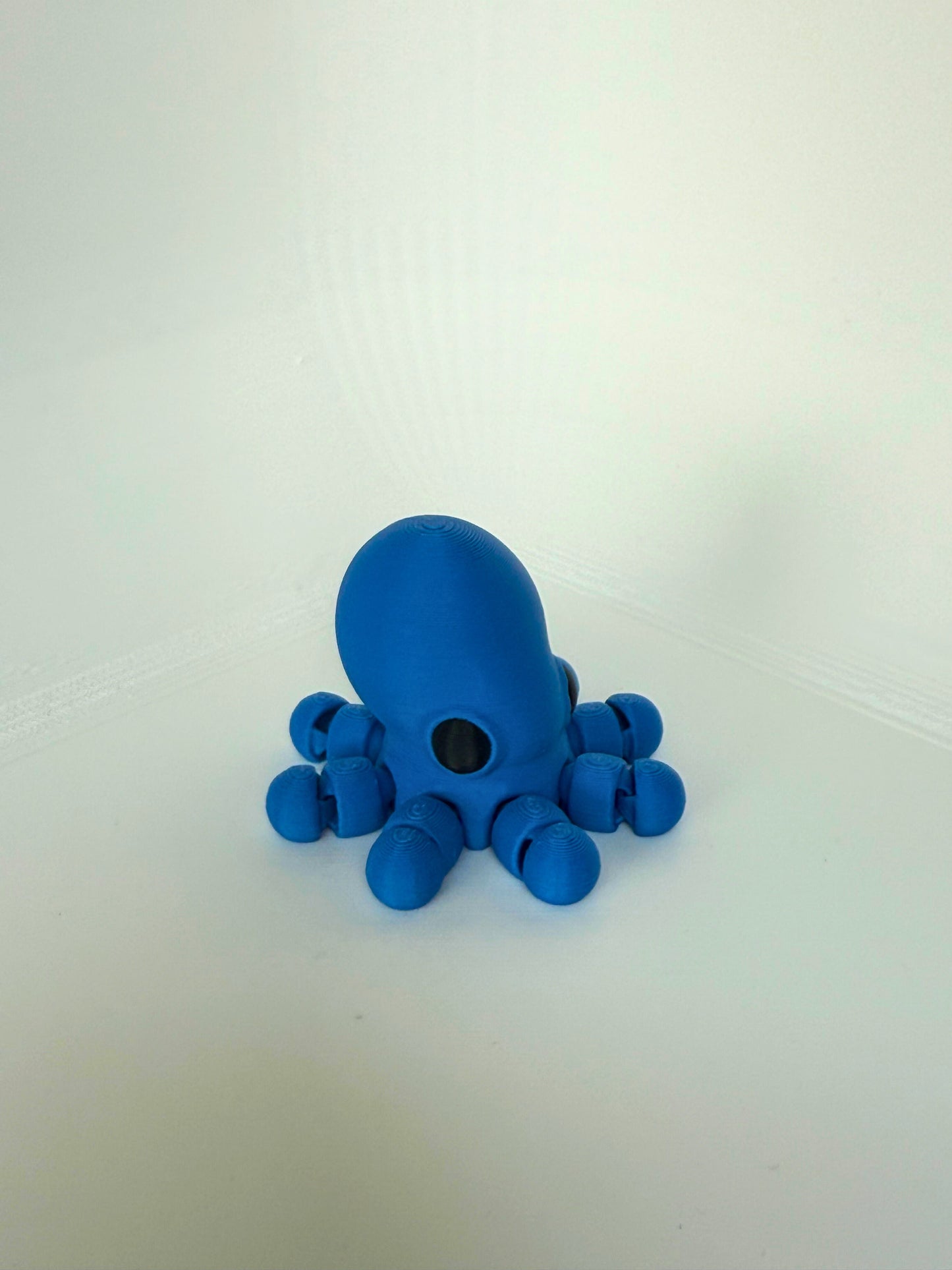 Duurzaam speelgoed: 3D-geprinte blauwe octopus met ronde kop en flexibele poten, achteraanzicht