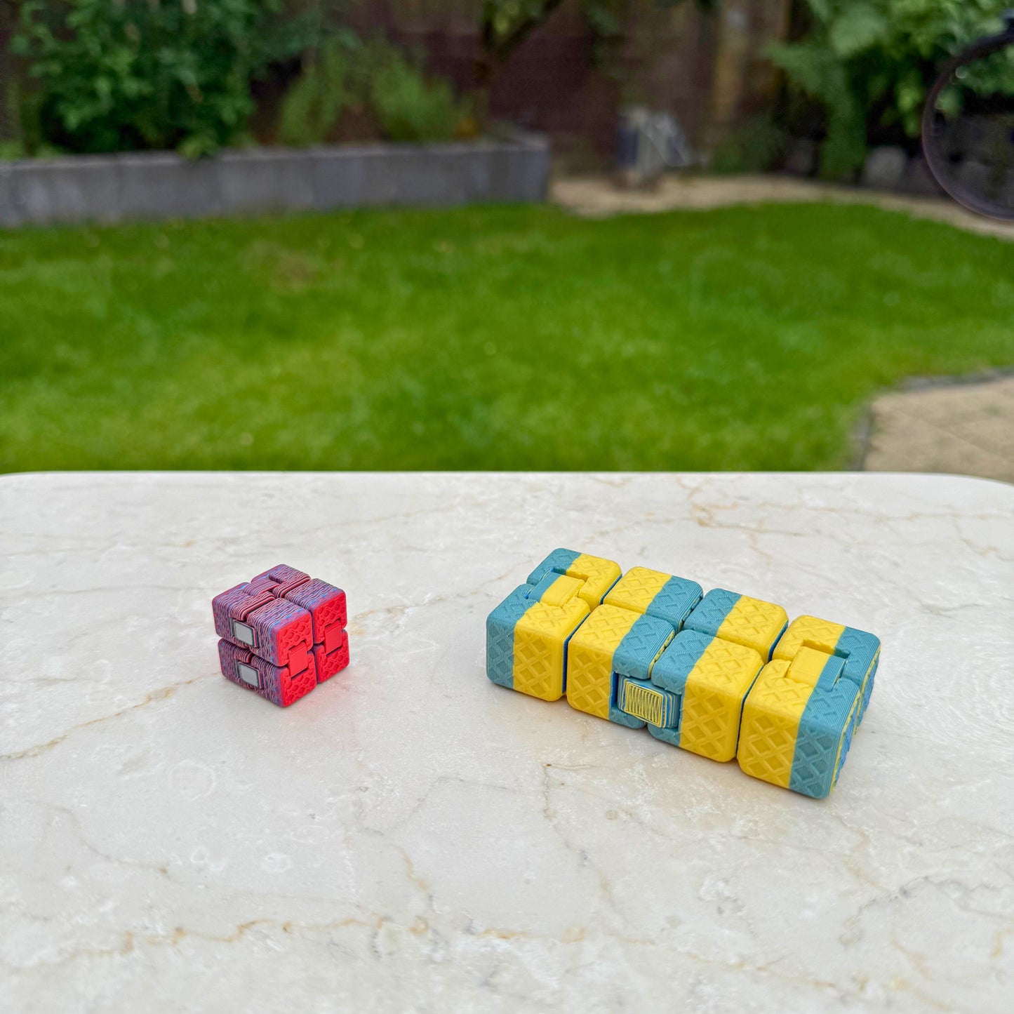 Detail van twee 3D geprinte infinity cubes, toont de scharnieren en het ontwerp.