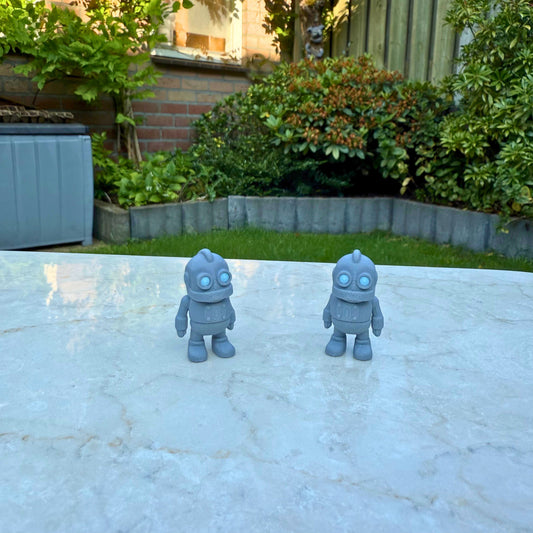 Twee grijze 3D geprinte flexibele robot speelgoedfiguren, met beweegbare armen en benen.