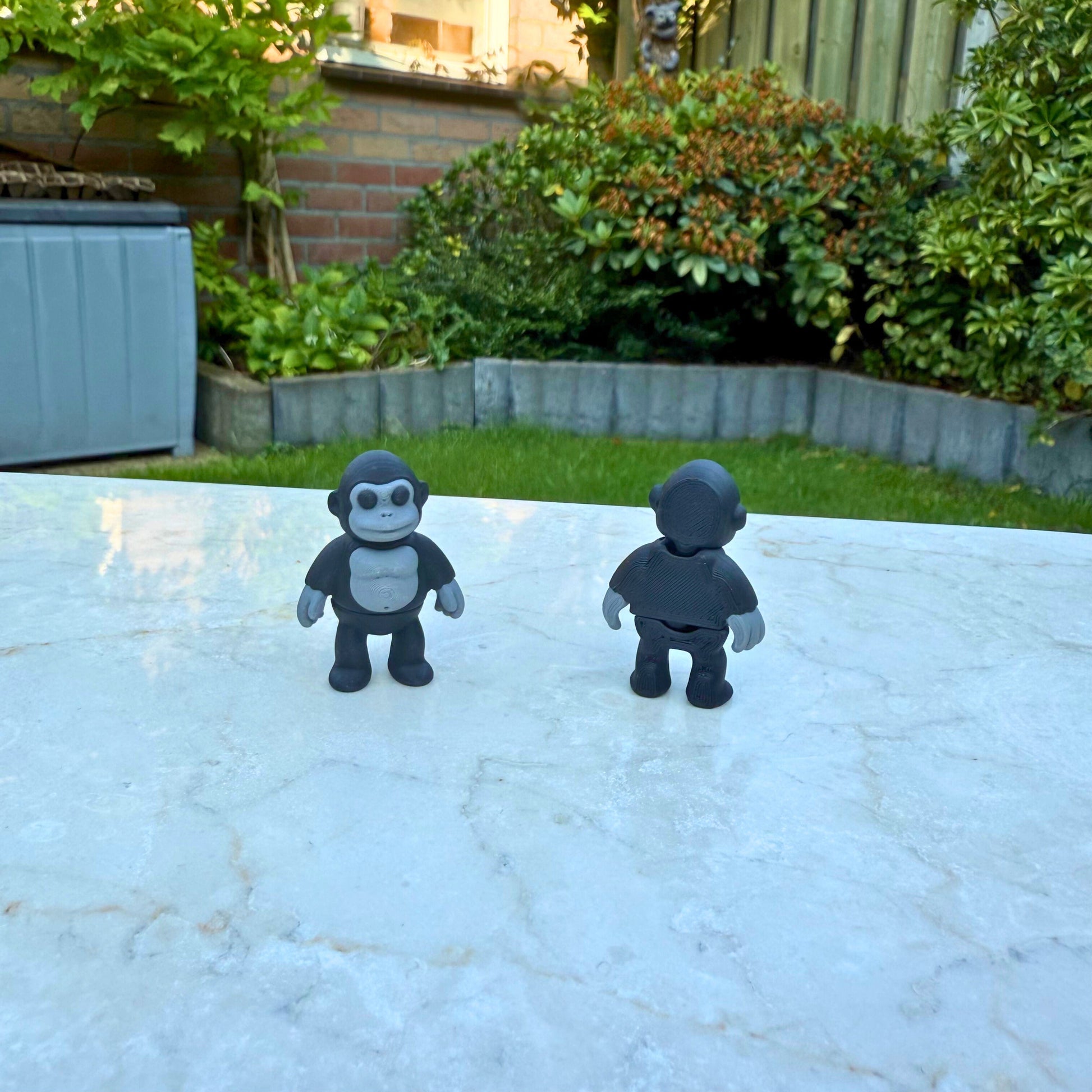 Voor- en achteraanzicht van een 3D geprinte flexibele gorilla van WereldjeMakers.