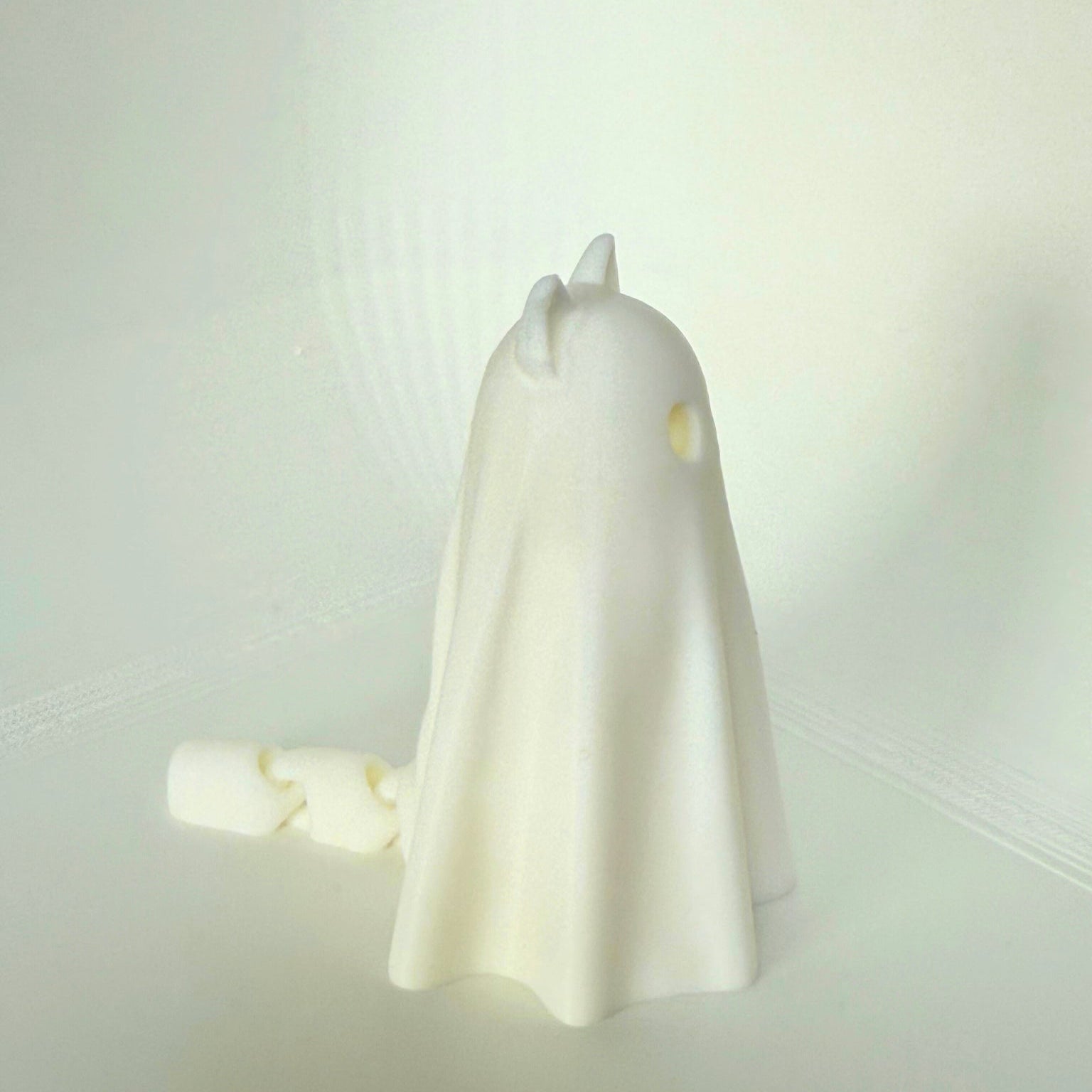 3D-geprinte spookkat van achteren gezien met een zichtbare kettingstaart, wat een speels detail toevoegt