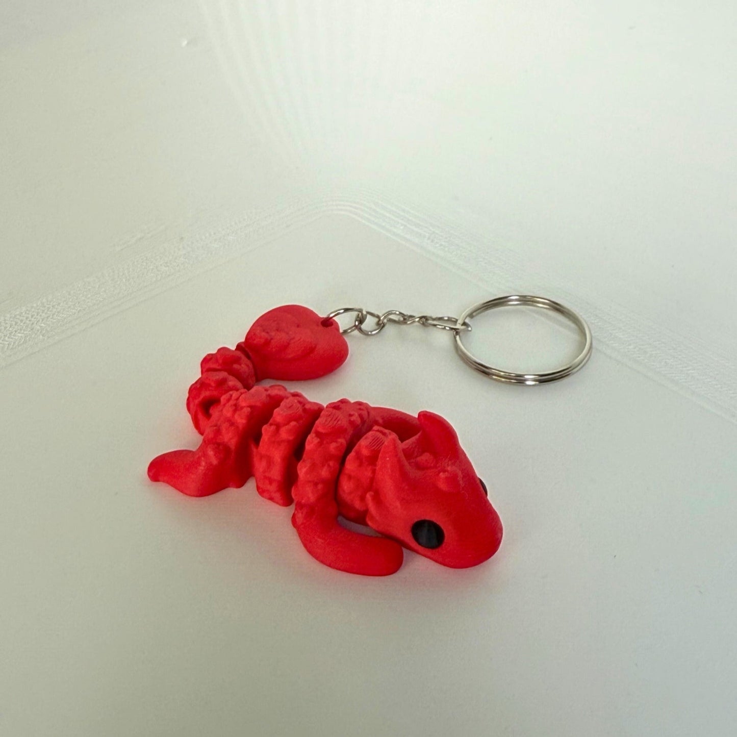 Liefdesdraak speelfiguur van PLA – rode 3D-geprinte draak met hartjes en sleutelhanger, liggend vooraanzicht