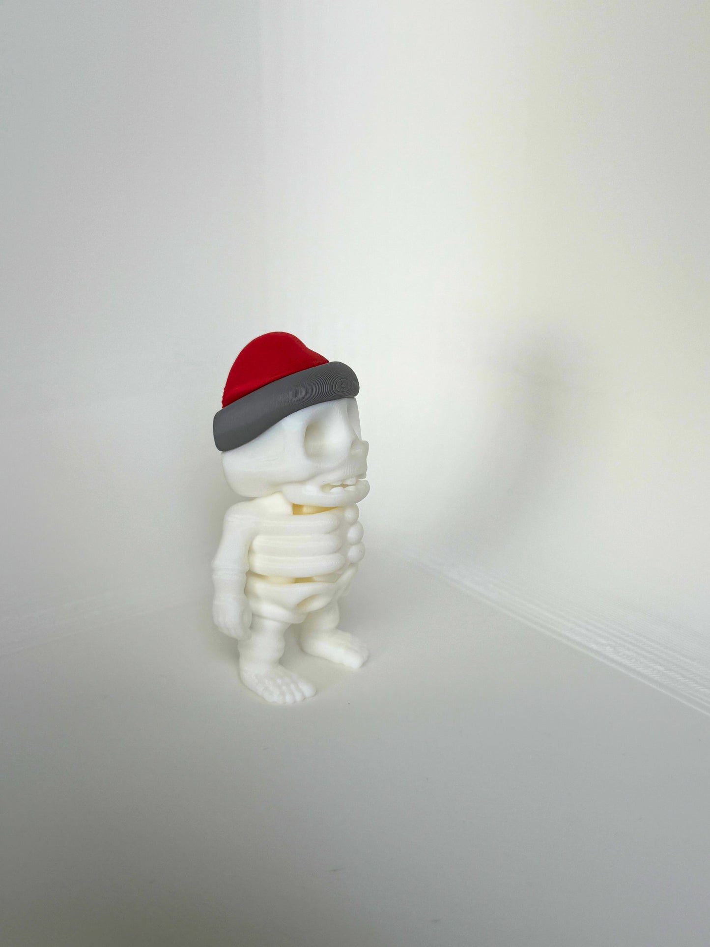 Duurzaam kinderspeelgoed in de vorm van een vrolijk skelet met rode kerstmuts – leuk als kerstcadeau