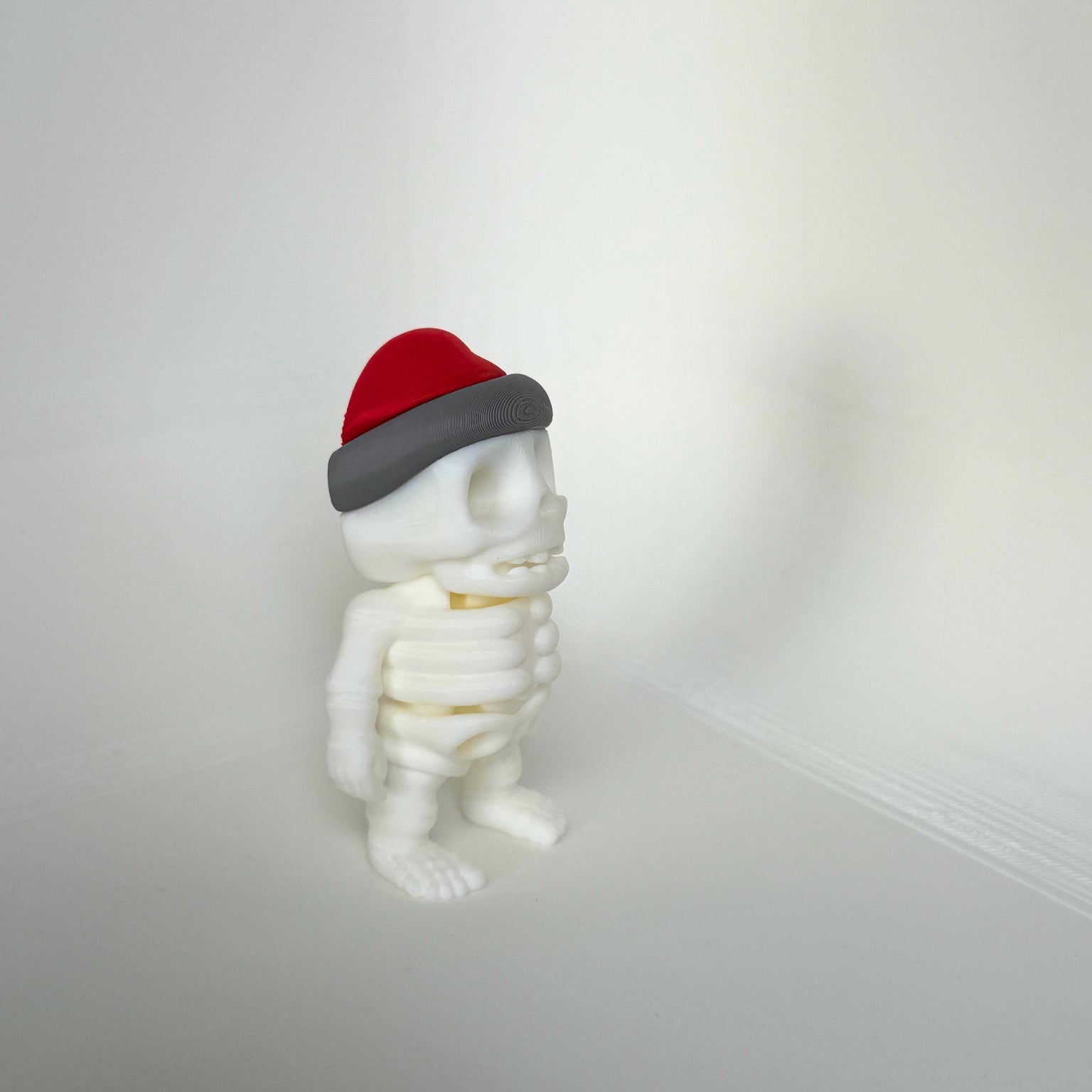 Duurzaam kinderspeelgoed in de vorm van een vrolijk skelet met rode kerstmuts – leuk als kerstcadeau