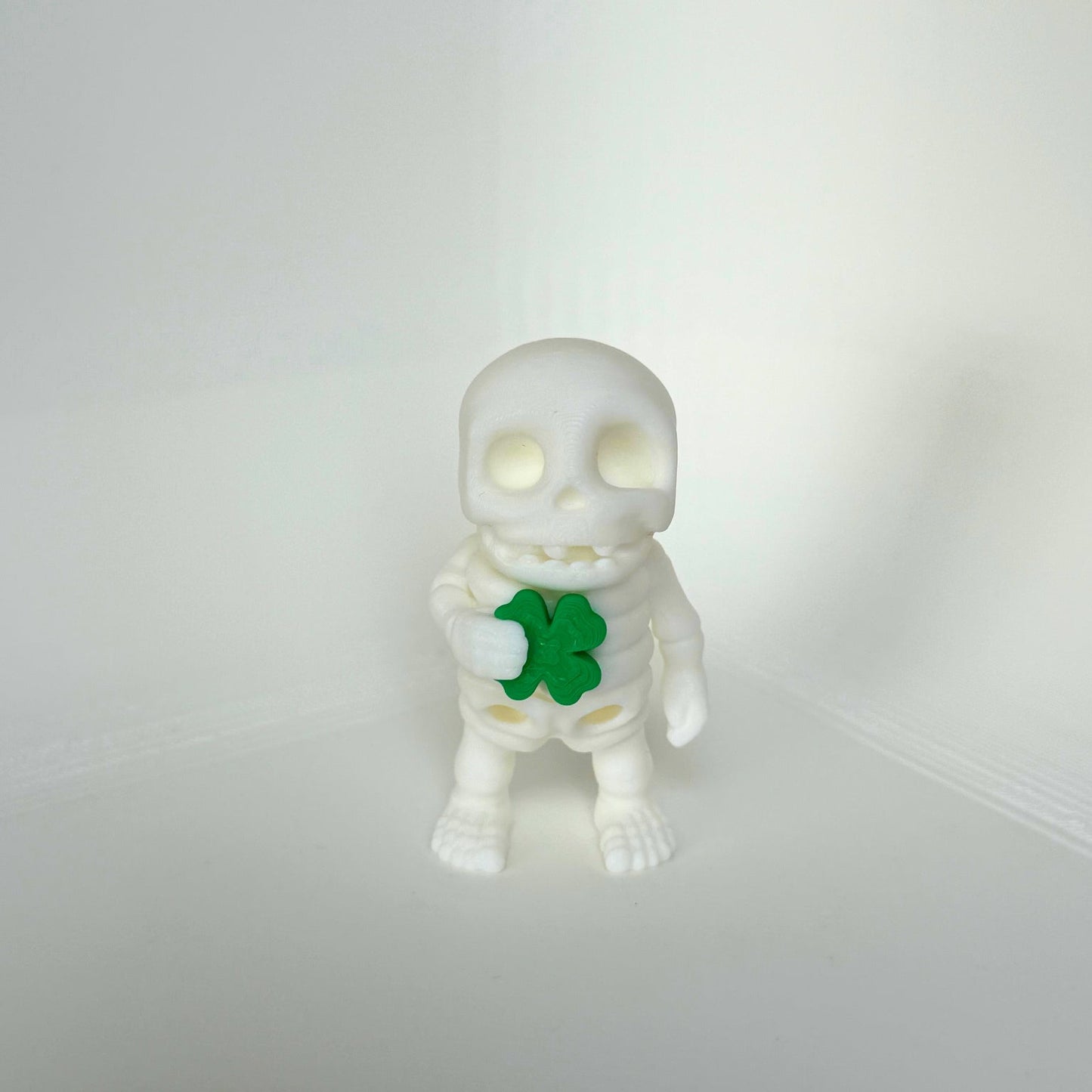 Schattig skeletfiguurtje met een klavertjevier in de hand – kindvriendelijk en milieuvriendelijk speelgoed.