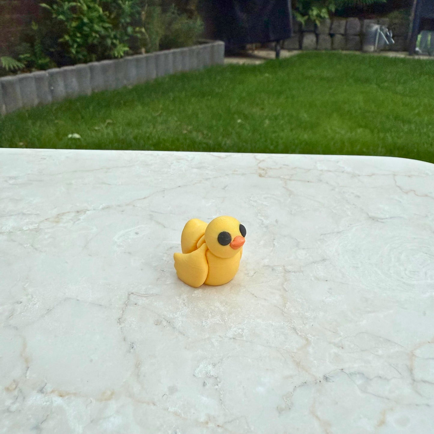 Flexibel model van een 3D geprint geel eendje, speelgoed met beweegbare delen voor kinderen.