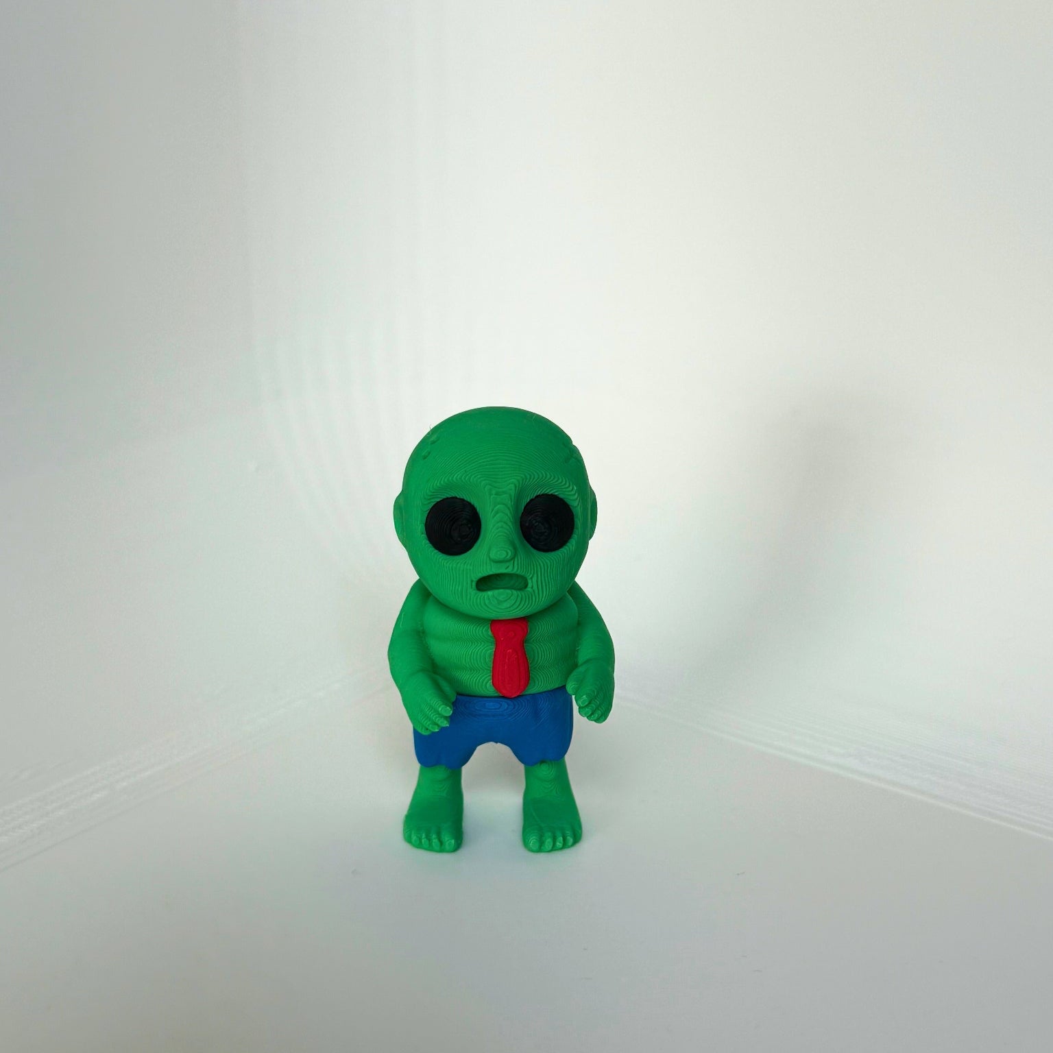 Kindvriendelijk 3D-geprint zombie speelfiguur in groene kleur met rode das en blauwe broek – voorkant
