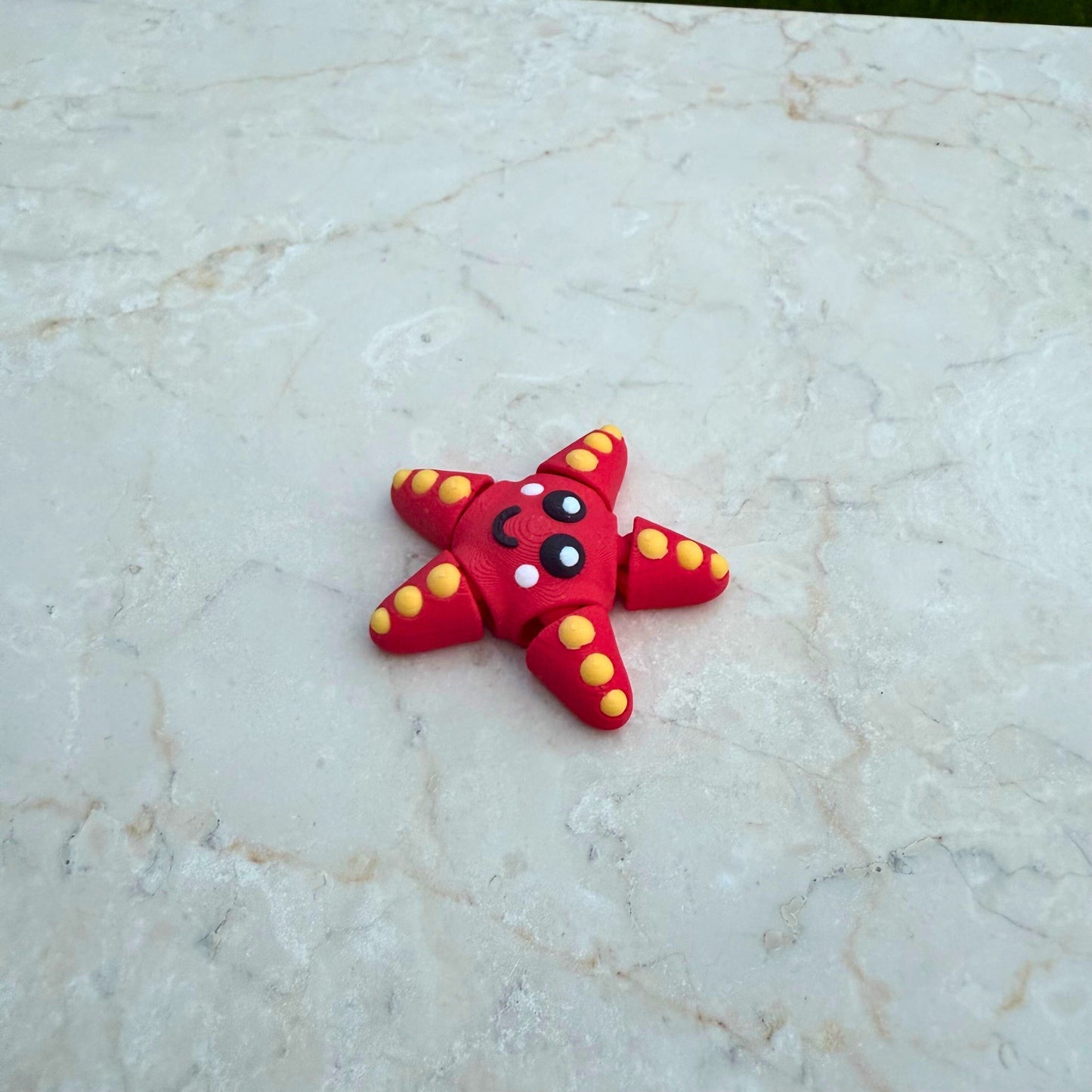 Speelgoed zeester met vijf flexibele armen, 3D geprint en veilig voor kinderen.