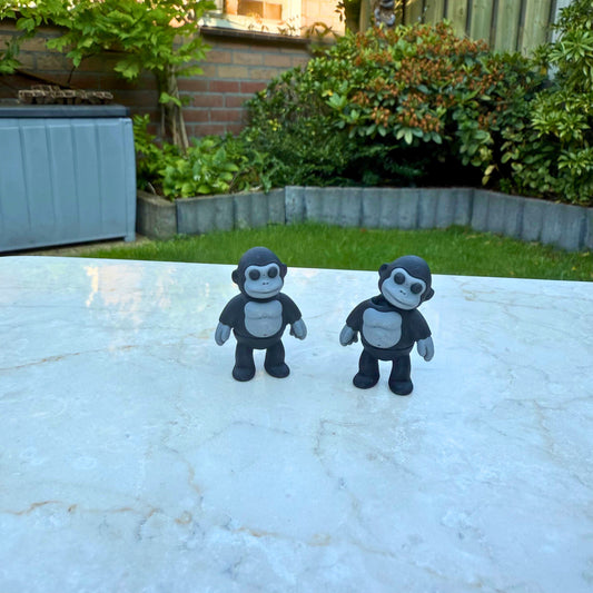 Twee 3D geprinte speelgoed gorilla's, ideaal voor het naspelen van een apenfamilie.