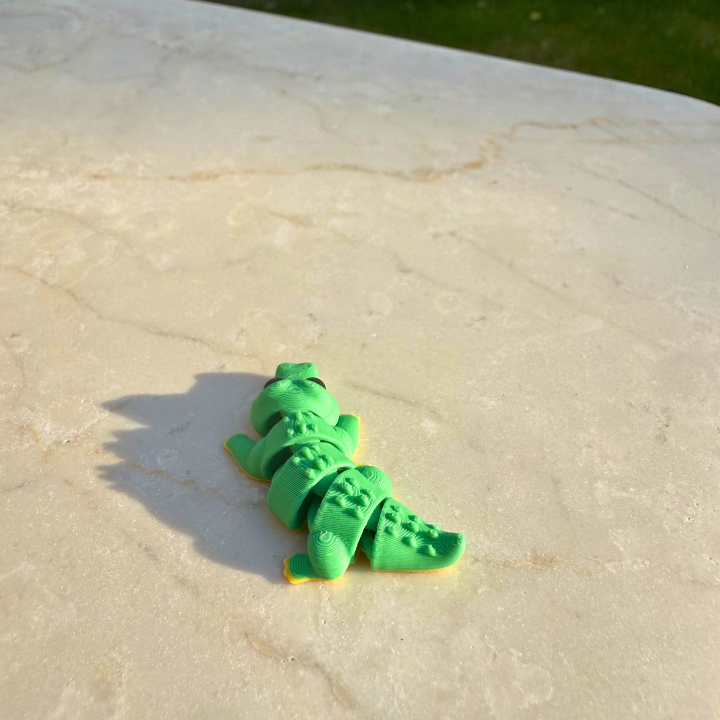 Speelgoedfiguur van een 3D geprinte flexibele krokodil, reptiel thema.