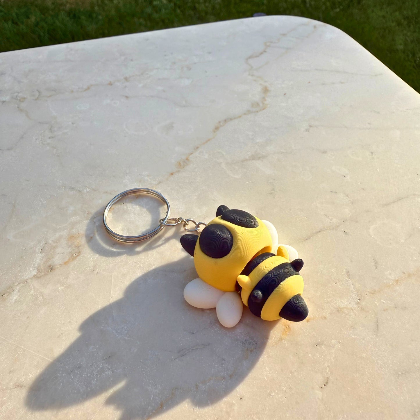 Detail van een 3D geprinte speelgoed bij, toont de articulatie en het gestreepte lichaam.