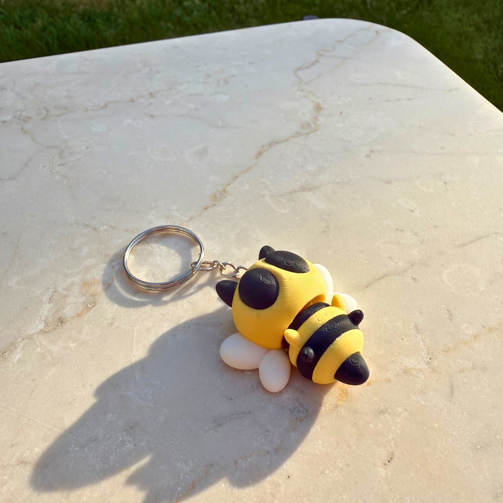 Detail van een 3D geprinte speelgoed bij, toont de articulatie en het gestreepte lichaam.