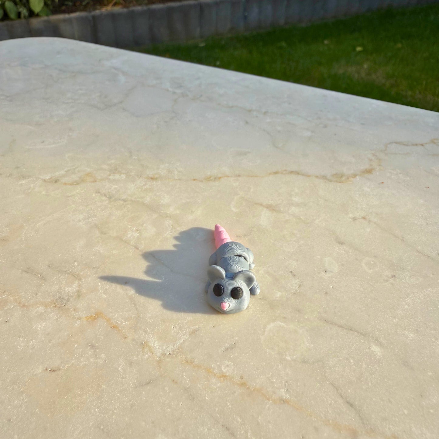 Detail van een 3D geprinte speelgoed muis, toont de articulatie en het schattige ontwerp.