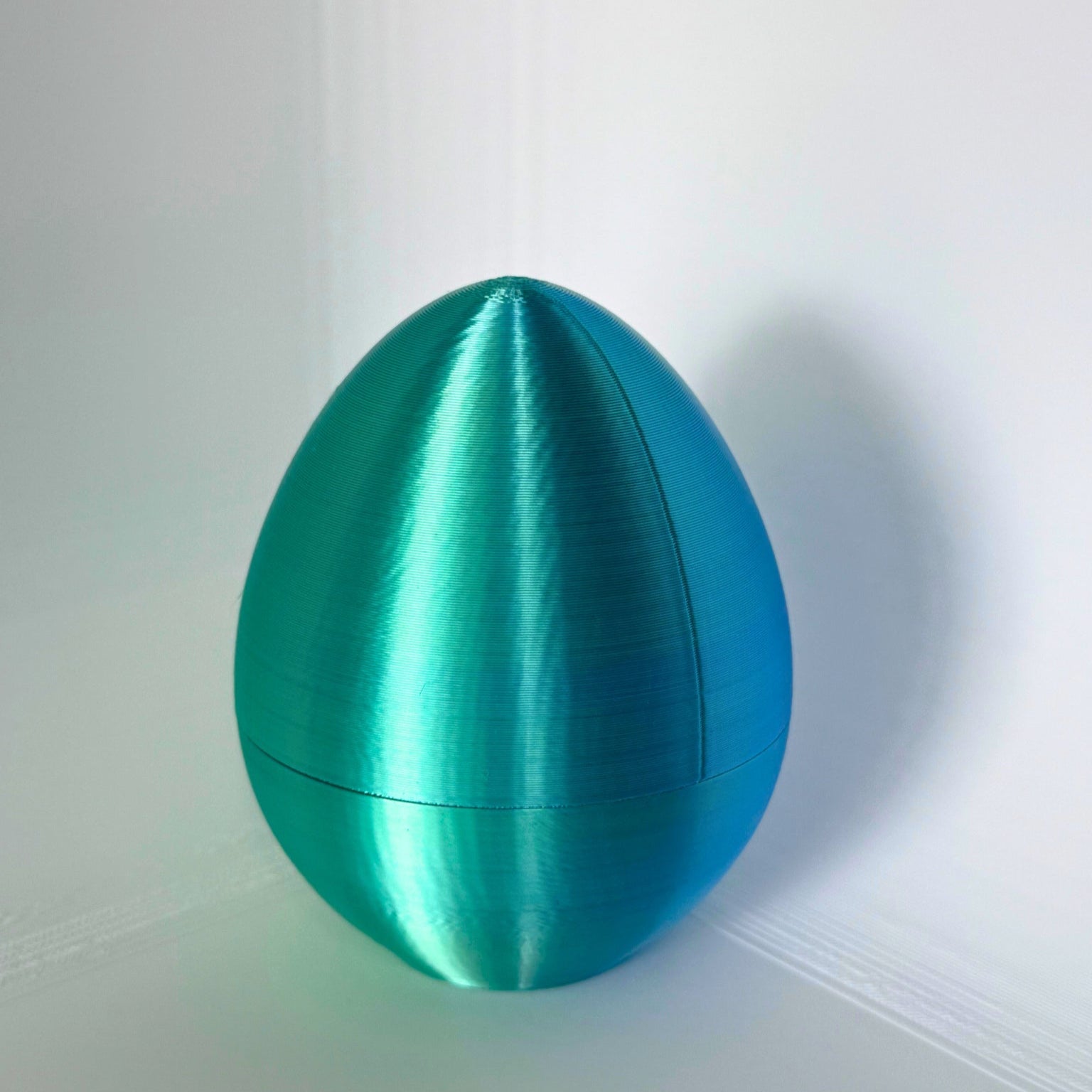 Gesloten blauwe ei-vormige container met metallic glans, ideaal als duurzame paasverpakking