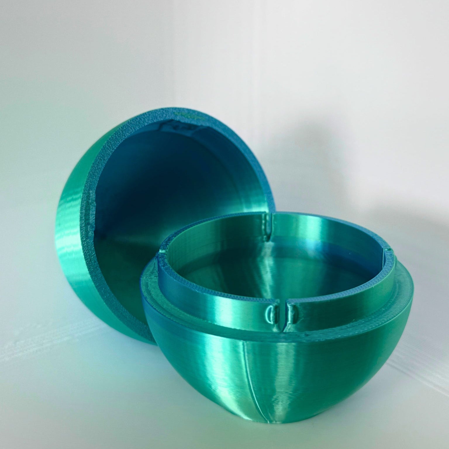 Open blauwe ei-vormige opbergdoos met glanzende afwerking, geschikt voor kleine cadeaus of verrassingen