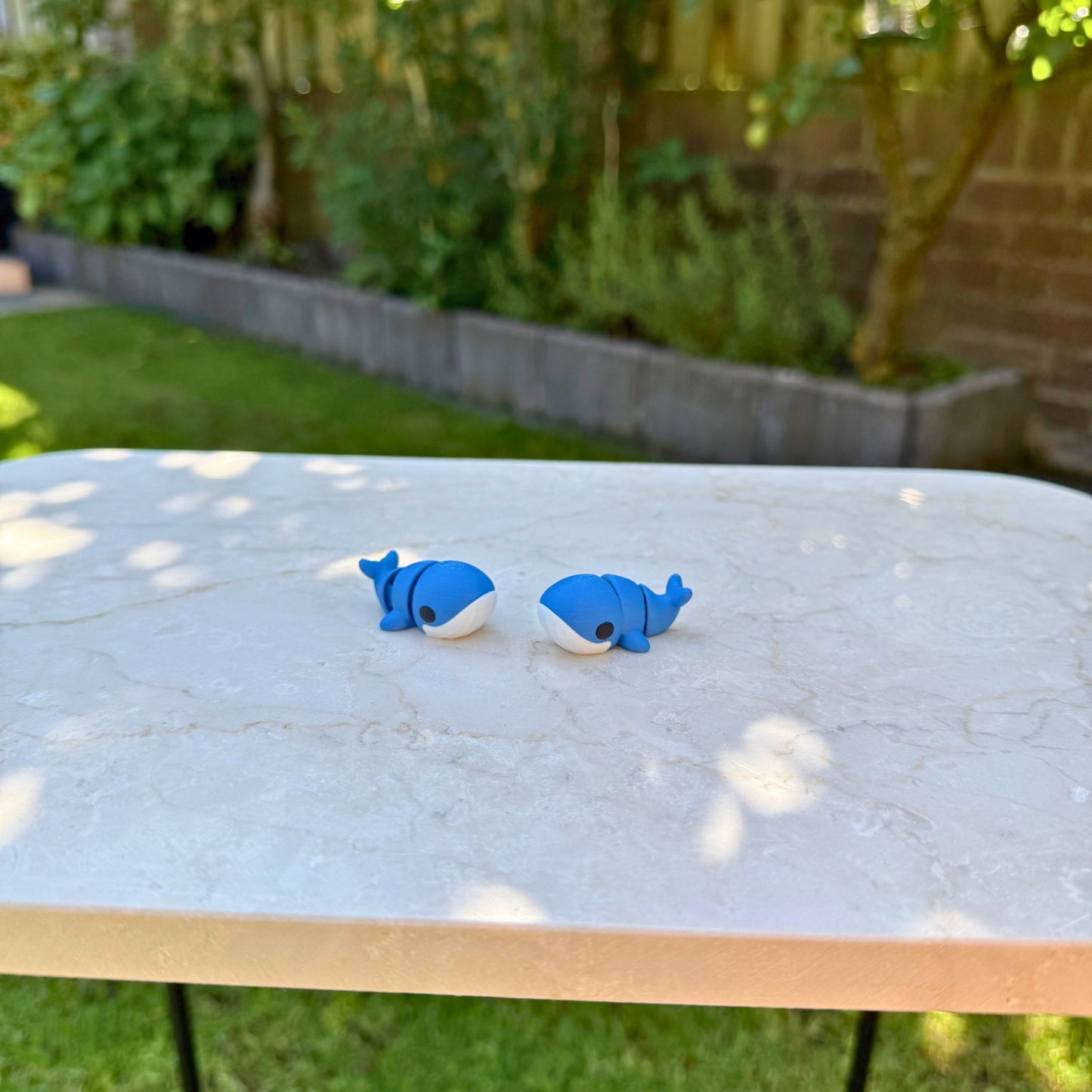 Twee blauwe 3D geprinte baby walvisjes, flexibel en ideaal voor fantasiespel.