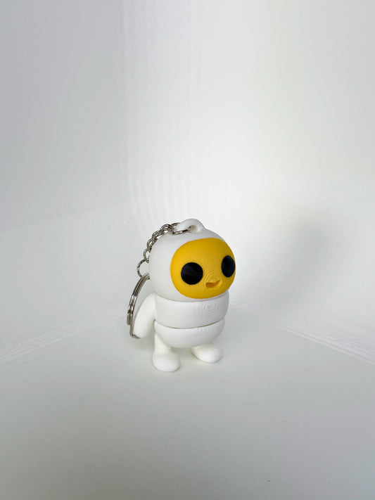 Kindvriendelijke sleutelhanger van Egg Boy – een schattig 3D-geprint figuur met een geel gezicht en witte outfit.