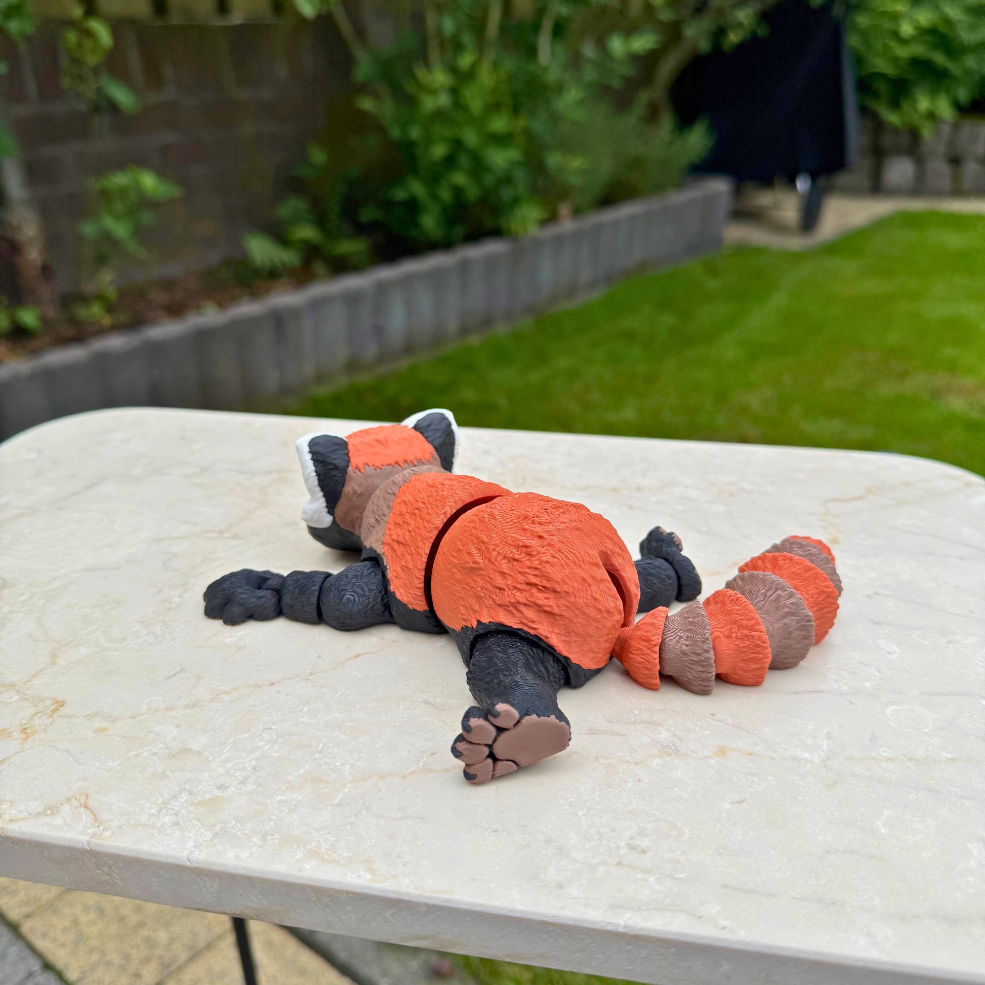 Liggend model van een 3D geprinte flexibele rode panda van WereldjeMakers, duurzaam PLA.