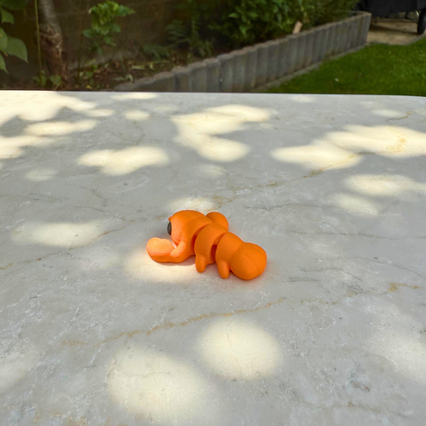 Detailopname van een flexibel 3D geprint baby kreeftje, toont de gearticuleerde segmenten.