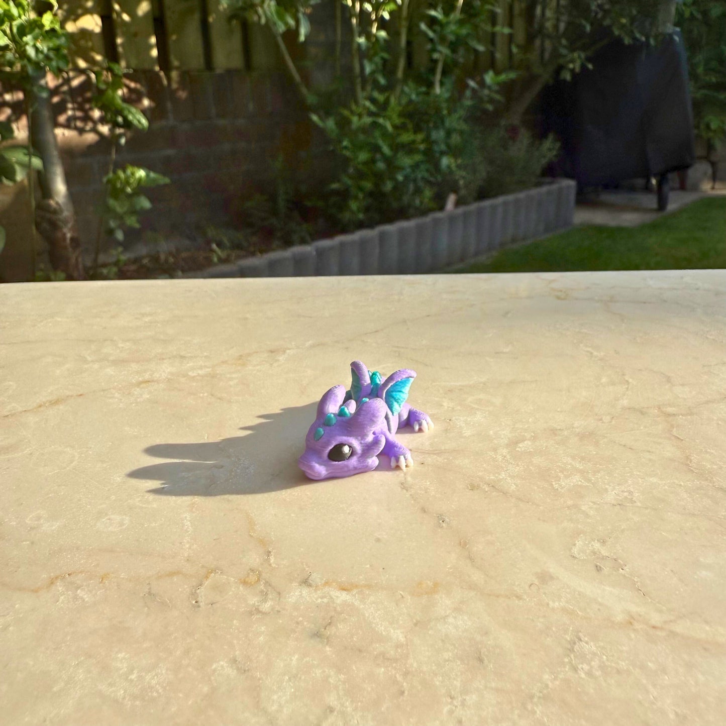 Paars flexibel model van een 3D geprint baby draakje (hatchling), speelgoed met beweegbare delen.