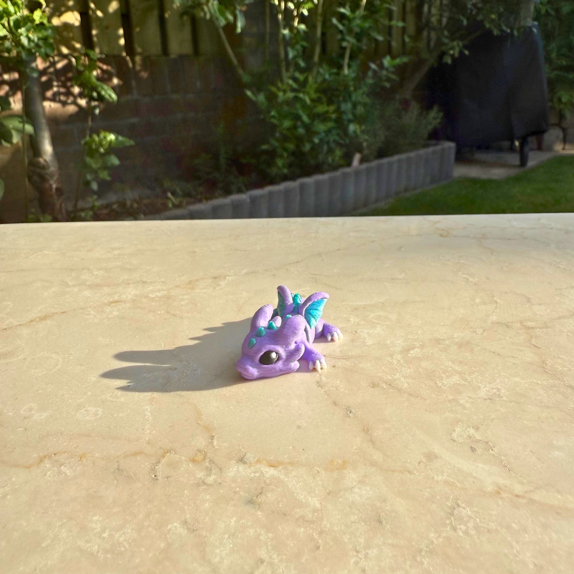 Paars flexibel model van een 3D geprint baby draakje (hatchling), speelgoed met beweegbare delen.