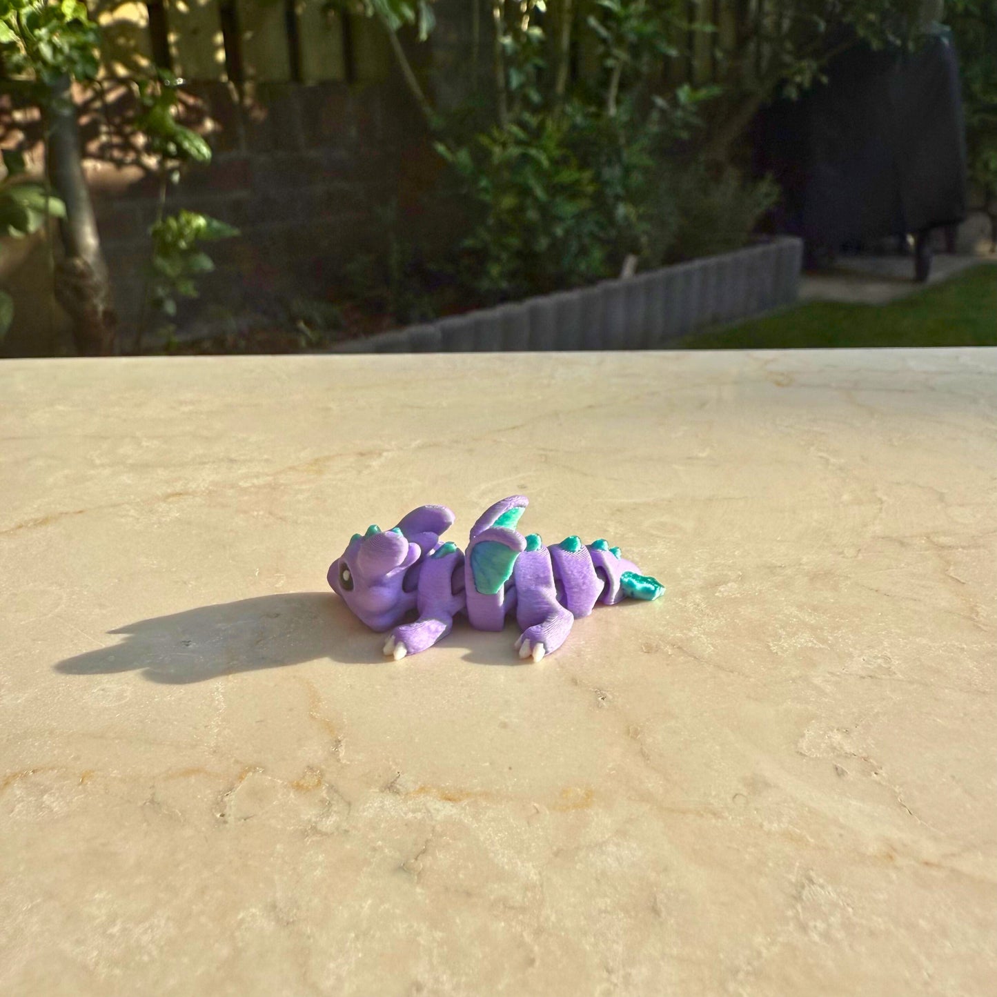 Paars flexibel model van een 3D geprint baby draakje (hatchling), speelgoed met beweegbare delen.