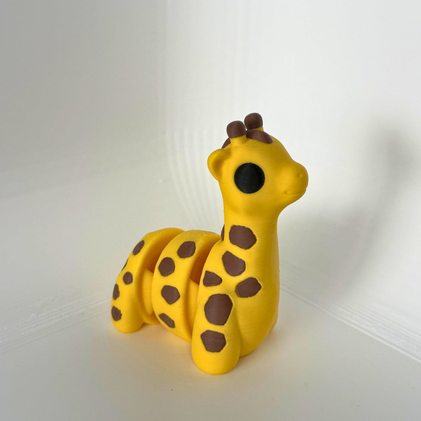 Vrolijke 3D-geprinte giraf met beweegbare segmenten en speelse bruine vlekken