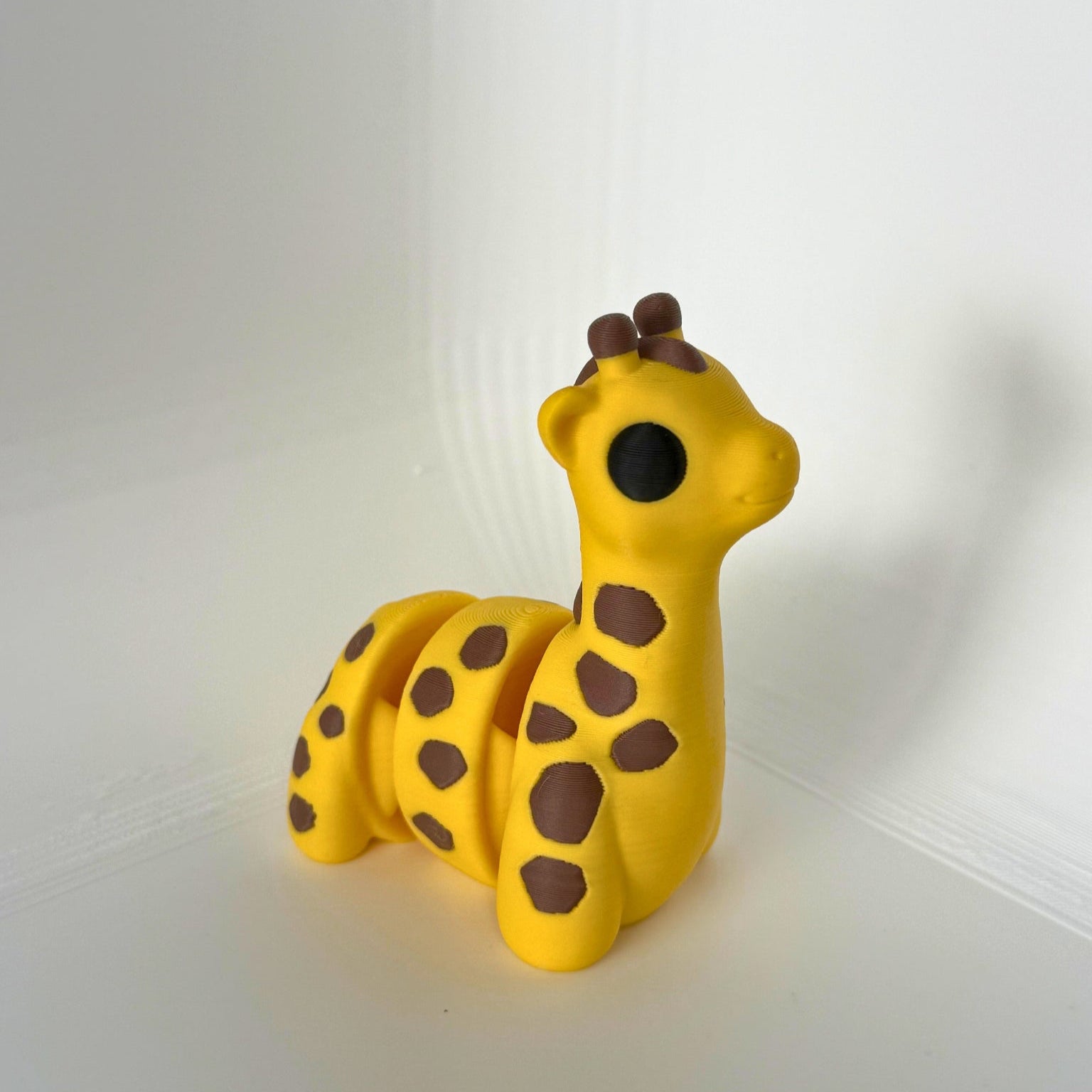 Vrolijke 3D-geprinte giraf met beweegbare segmenten en speelse bruine vlekken