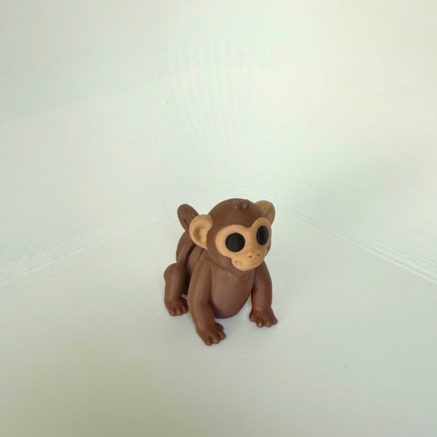 Kindvriendelijk speelgoed: bruin 3D-geprint aap speelfiguur met grote ogen, vooraanzicht
