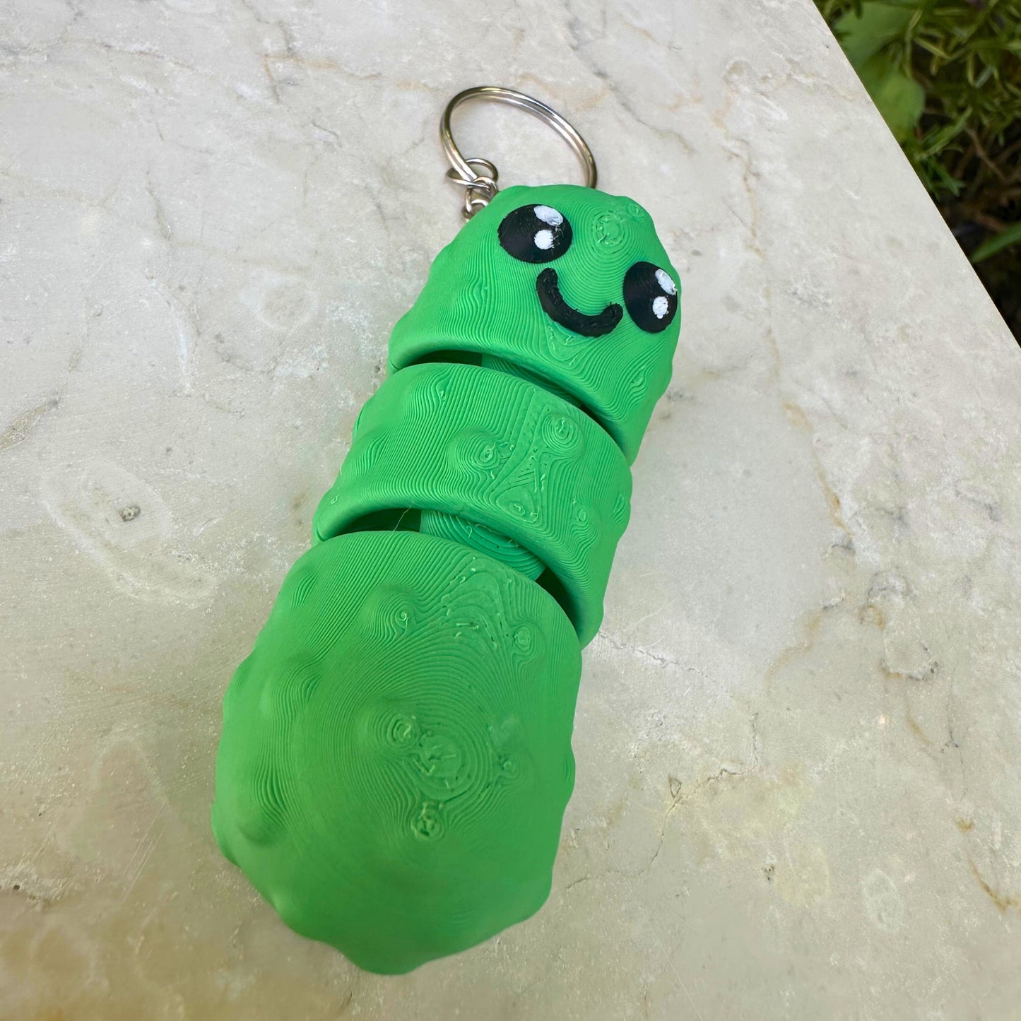 Lachende 3D geprinte augurk als sleutelhanger, vrolijk en duurzaam accessoire.