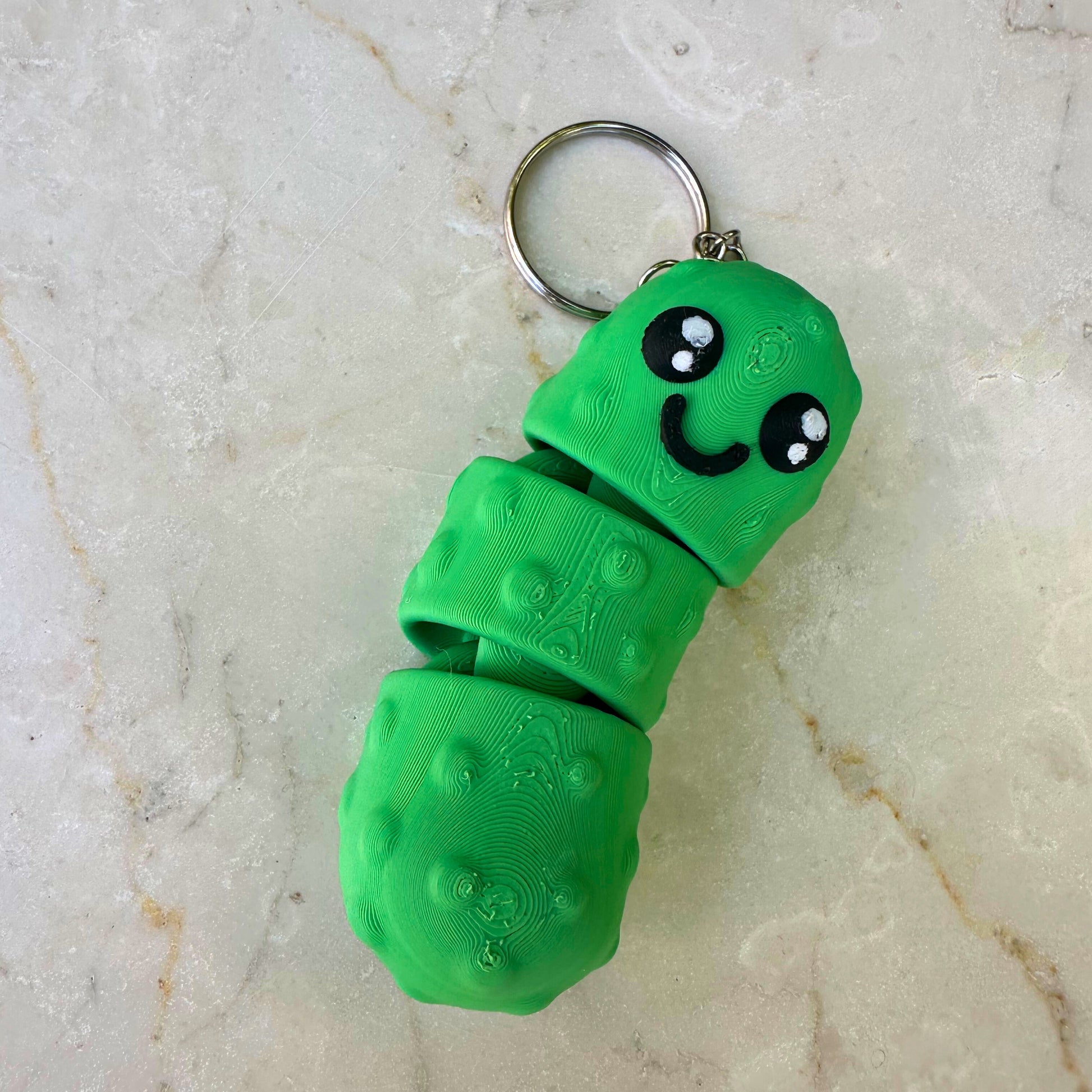 Groene lachende 3D geprinte flexibele augurk, duurzaam PLA speelgoed, met zichtbare segmenten.