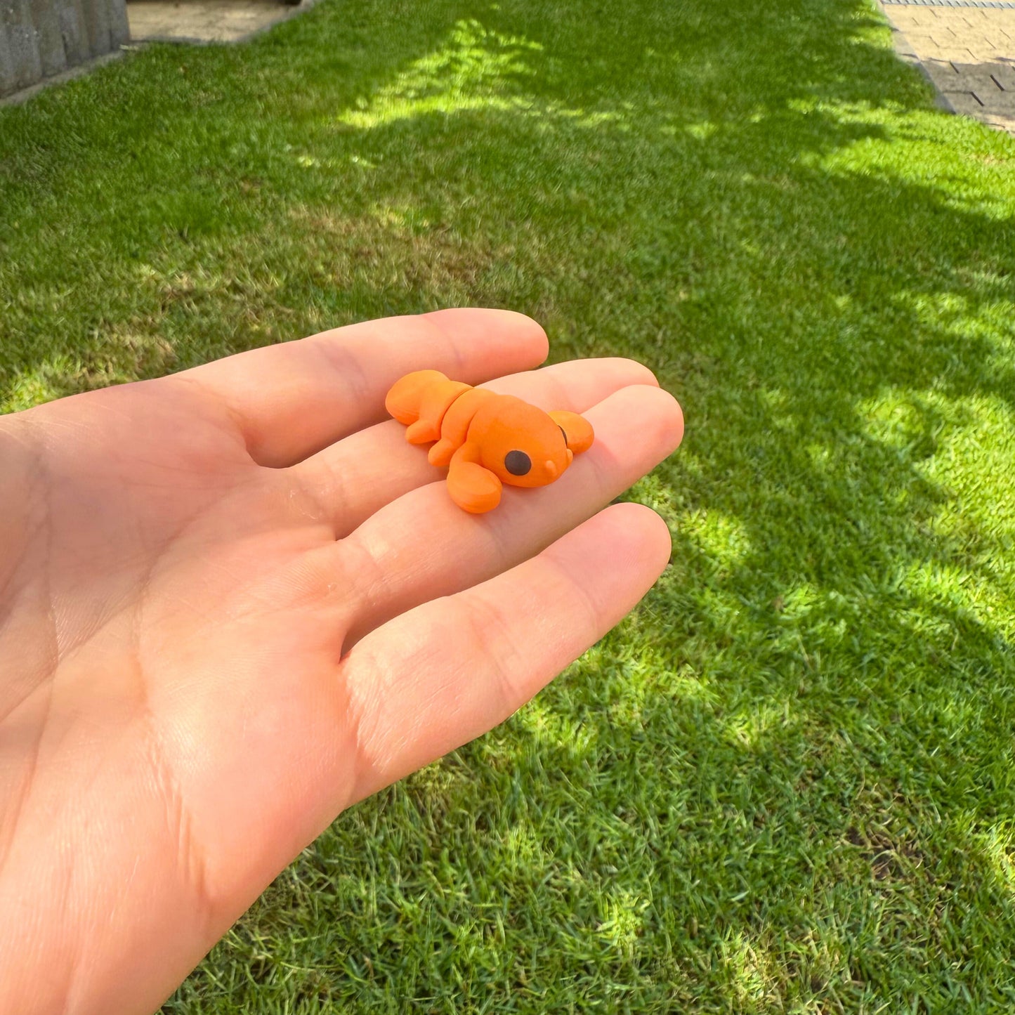 Flexibel oranje baby kreeftje, 3D geprint speelgoed, ideaal voor fantasierijk spel.
