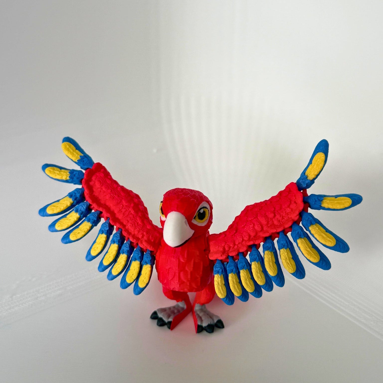 Rode papegaai met gespreide vleugels in een kleurrijke pose van voren gezien.