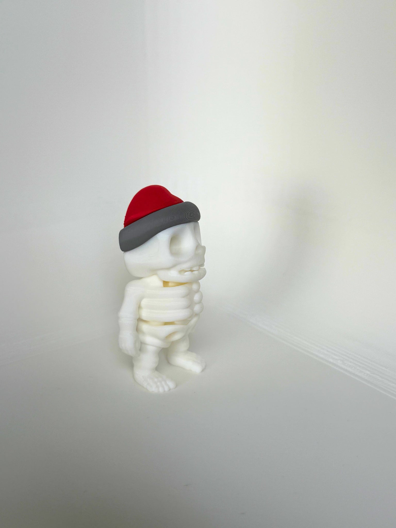 Duurzaam kinderspeelgoed in de vorm van een vrolijk skelet met rode kerstmuts – leuk als kerstcadeau
