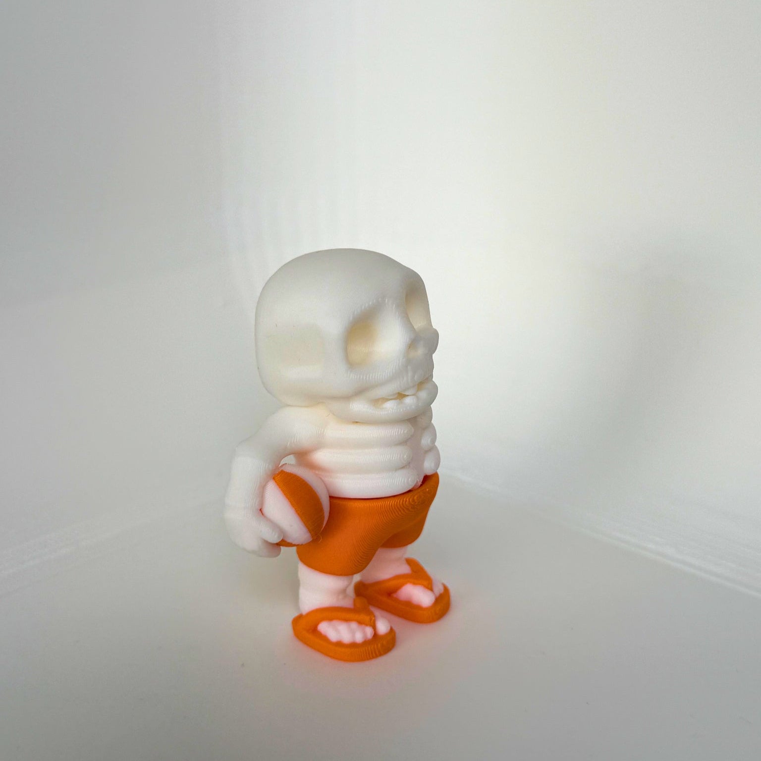 3D-printed summer skeleton toy holding a beach ball, designed for kids and sustainable play