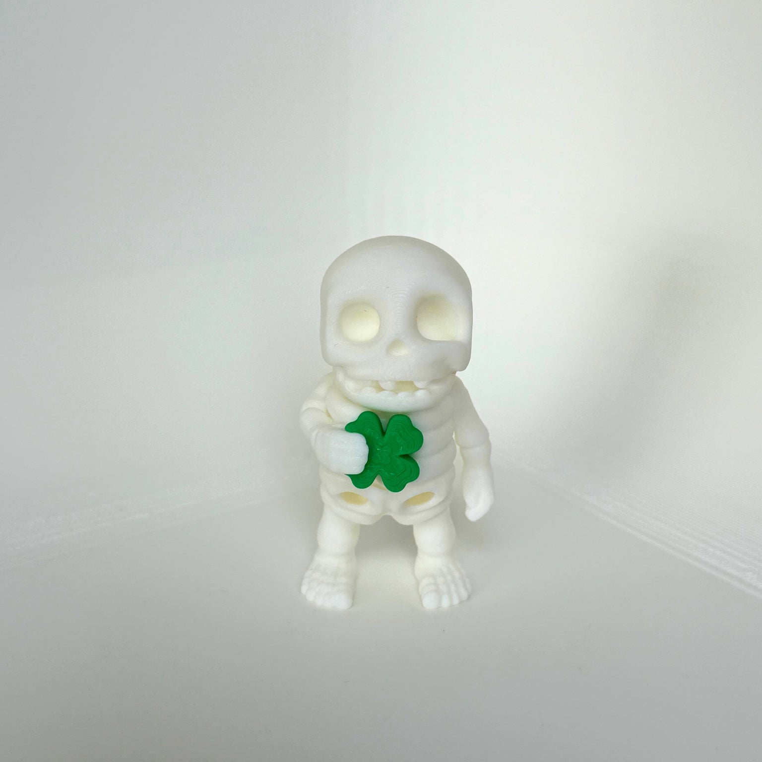 Schattig skeletfiguurtje met een klavertjevier in de hand – kindvriendelijk en milieuvriendelijk speelgoed.